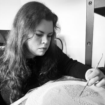 photo of Una Galbraith making marks into glass powder